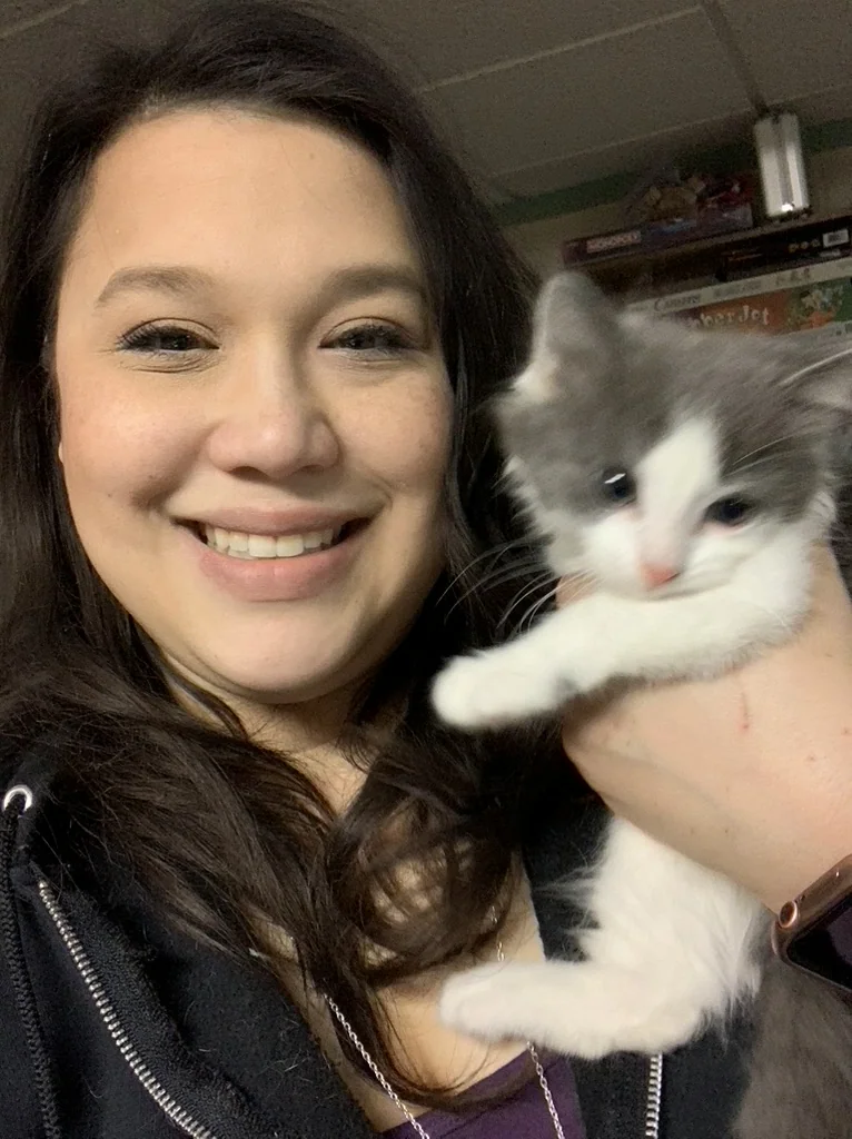 Missy holding a gray and white kitten