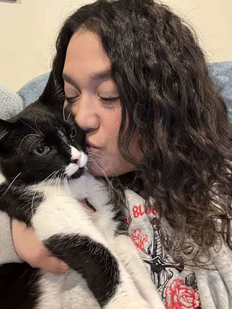 Missy cuddling a black and white cat