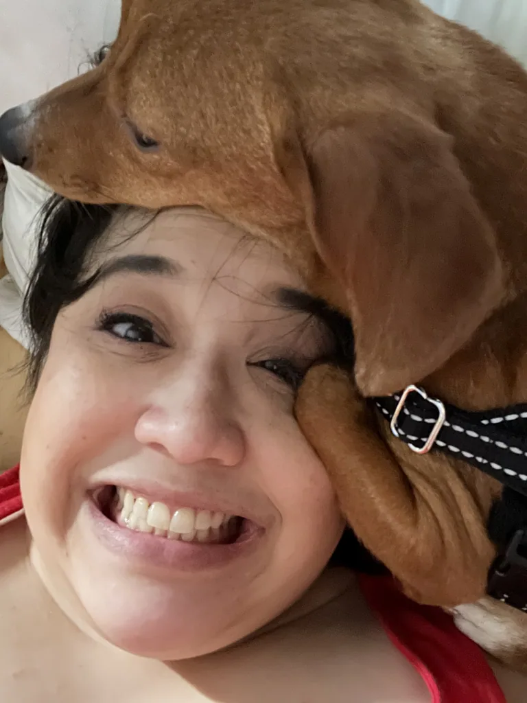 Missy with a small brown dog cuddling her head