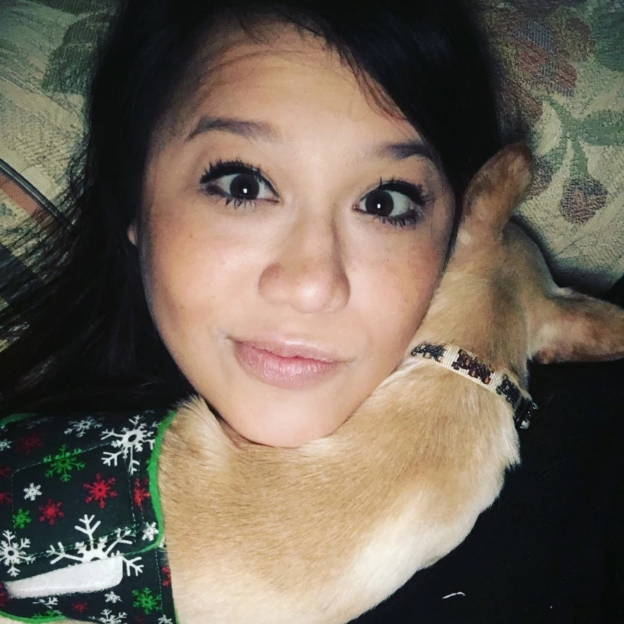 Missy snuggling with a Chihuahua in winter clothes